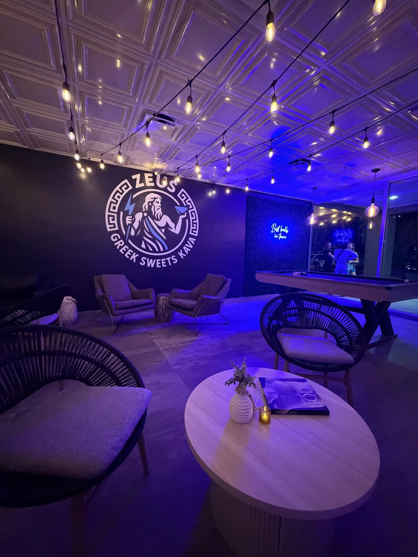 Zeus Greek lounge at night with blue lighting and the Zeus wall mark